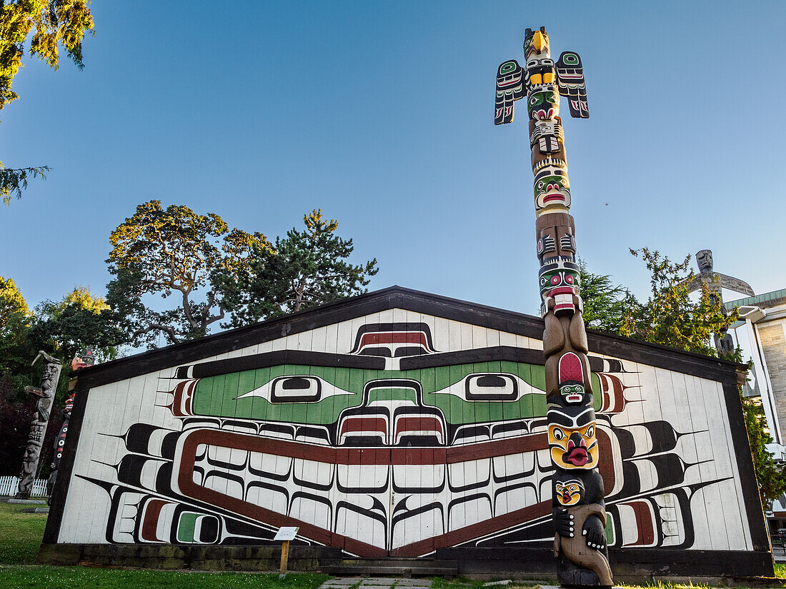 Totempfähle der Ureinwohner und Big House, Thunderbird Park, Vancouver Island, neben dem Royal British Columbia Museum, Victoria, British Columbia, Kanada, Nordamerika