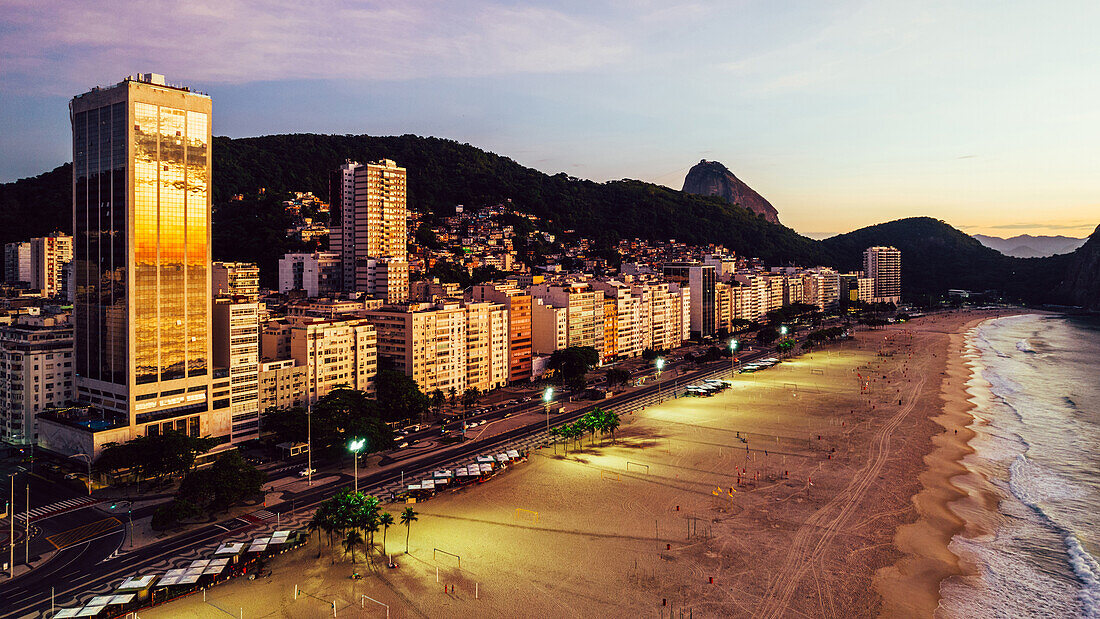 Aerial drone view of Leme Beach in the Copacabana district at sunrise with the iconic Sugarloaf Mountain in the background, UNESCO World Heritage Site, Rio de Janeiro, Brazil, South America