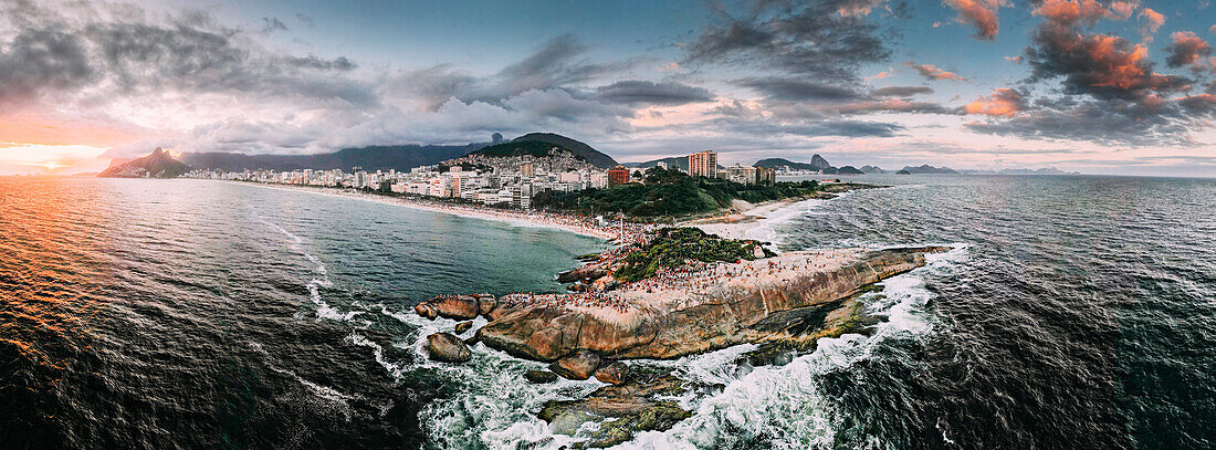 Drohnenpanorama der Strände Ipanema und Copacabana bei Sonnenuntergang mit dem Arpoador-Felsen im Vordergrund und dem Zuckerhut, Rio de Janeiro, Brasilien, Südamerika