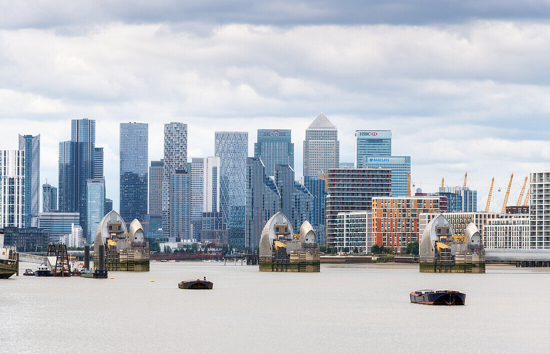 Das Themse-Hochwassersperrwerk, eines der größten beweglichen Hochwassersperrwerke der Welt, mit Canary Wharf und Docklands im Hintergrund, London, England, Vereinigtes Königreich, Europa
