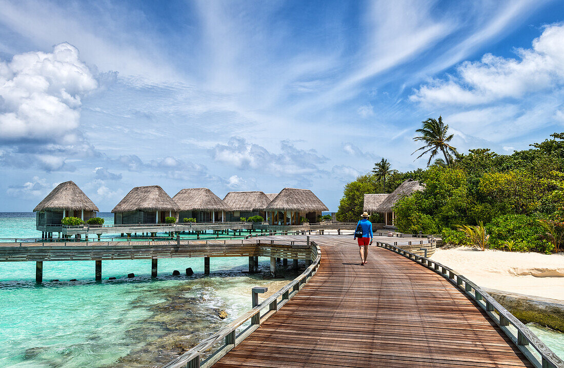 Mann spaziert auf einem Holzsteg, Baa Atoll, Malediven, Indischer Ozean, Asien