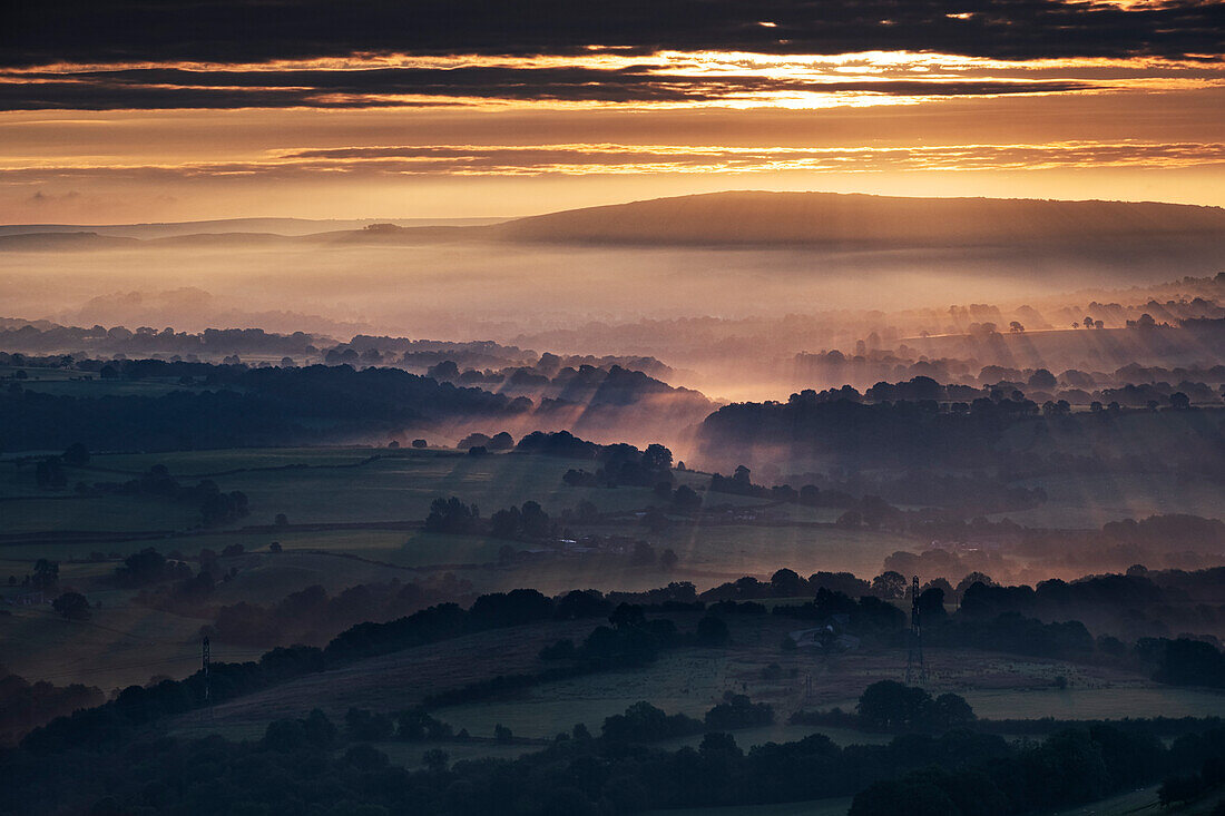 Morgensonnenstrahlen und Frühnebel bedecken die Cheshire-Ebene bei Sonnenaufgang, von Bosley Cloud, Cheshire, England, Vereinigtes Königreich, Europa