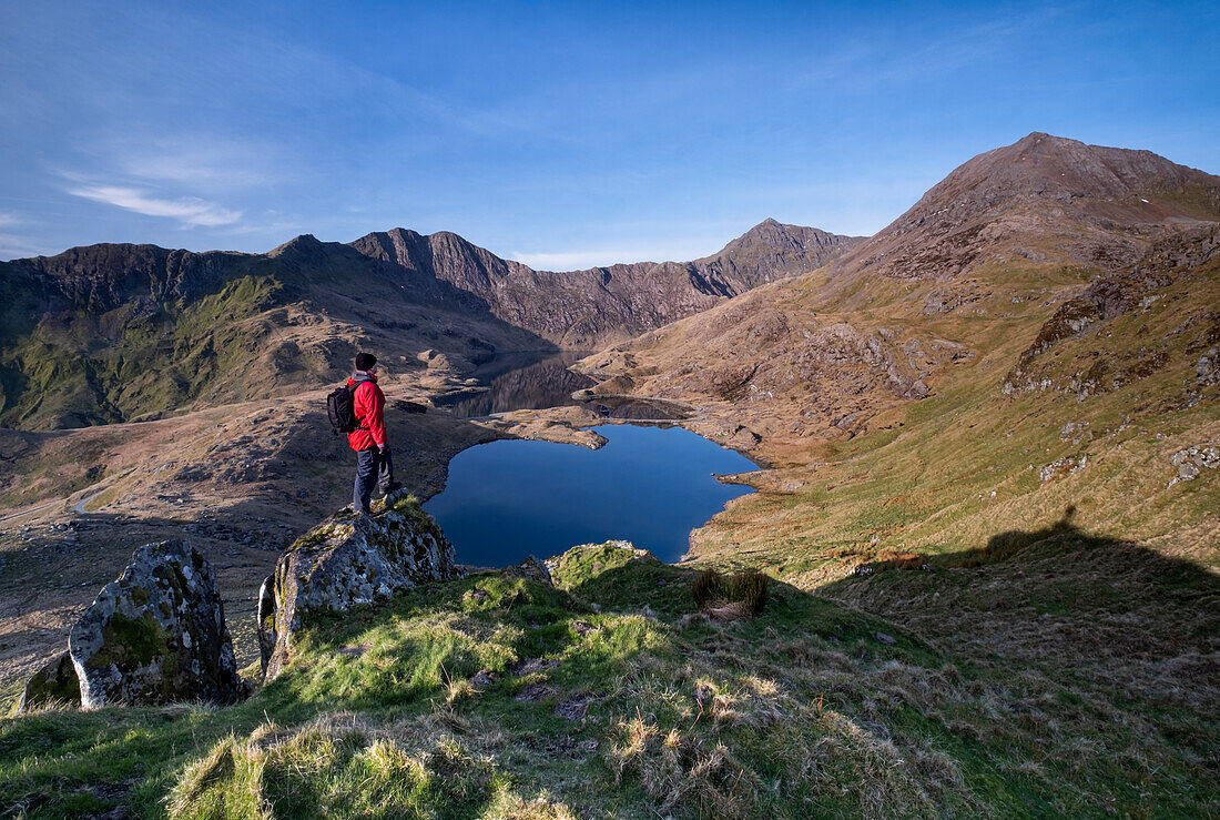 Walker looking out over Cwm Dyli and Llyn Llydaw to Snowdon and the Snowdon Horseshoe, Snowdonia National Park, North Wales, United Kingdom, Europe
