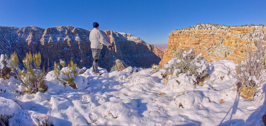 Ein Wanderer steht auf einer schneebedeckten Klippe am Ostrand des Grand Canyon National Park, UNESCO Weltnaturerbe, Arizona, Vereinigte Staaten von Amerika, Nordamerika