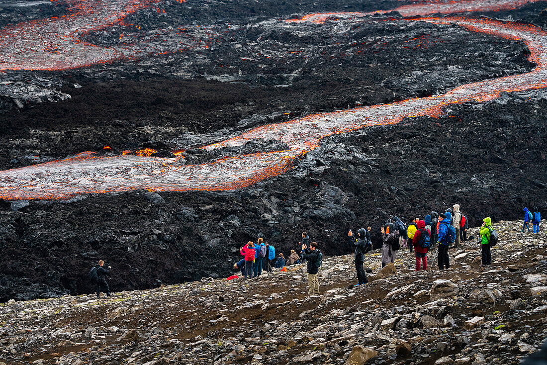Tourists watching flowing lava at Fagradalsfjall volcano, Reykjanes Peninsula, Iceland, Polar Regions