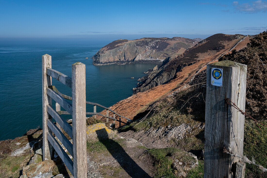 Gate and coast path sign framing Llanlleiana Head on The Anglesey Coastal Path, near Cemaes, Anglesey, North Wales, United Kingdom, Europe