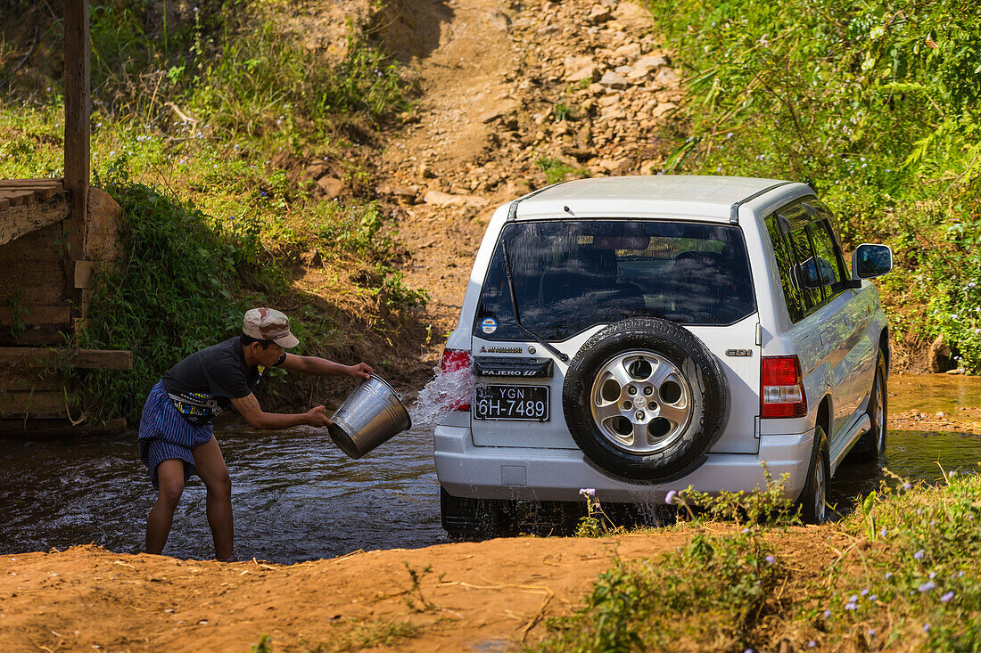 Man washing his car with water from river, near Hsipaw, Shan State, Myanmar (Burma), Asia