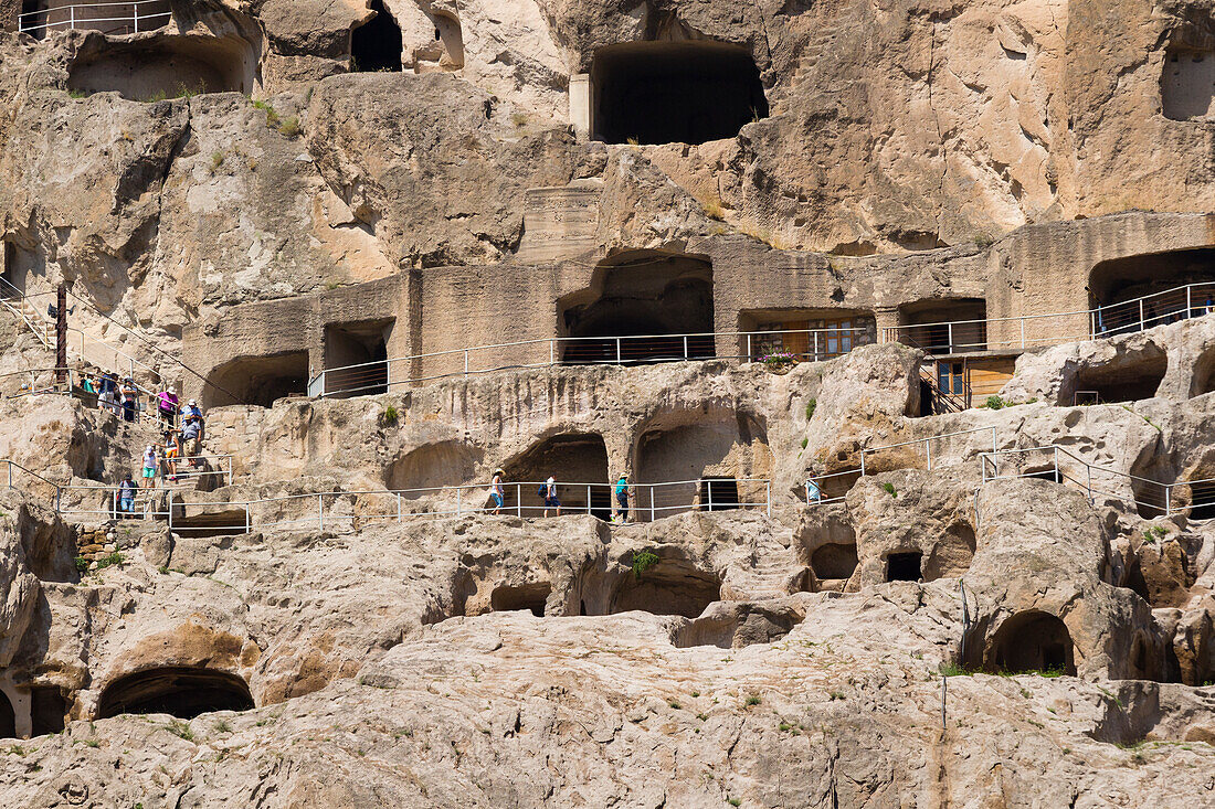 Tourists exploring ancient cave city of Vardzia, Georgia, Central Asia, Asia