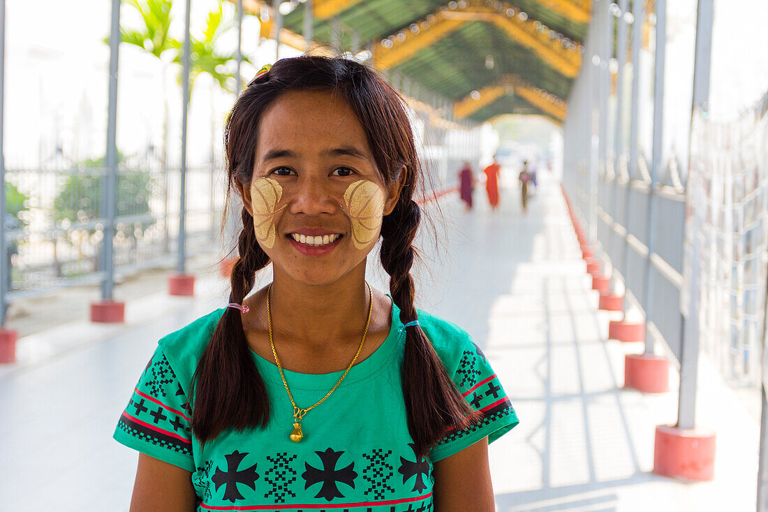 Young Burmese woman with leaves painted on her cheeks with thanaka, Sandamuni Pagoda, Mandalay, Myanmar (Burma), Asia