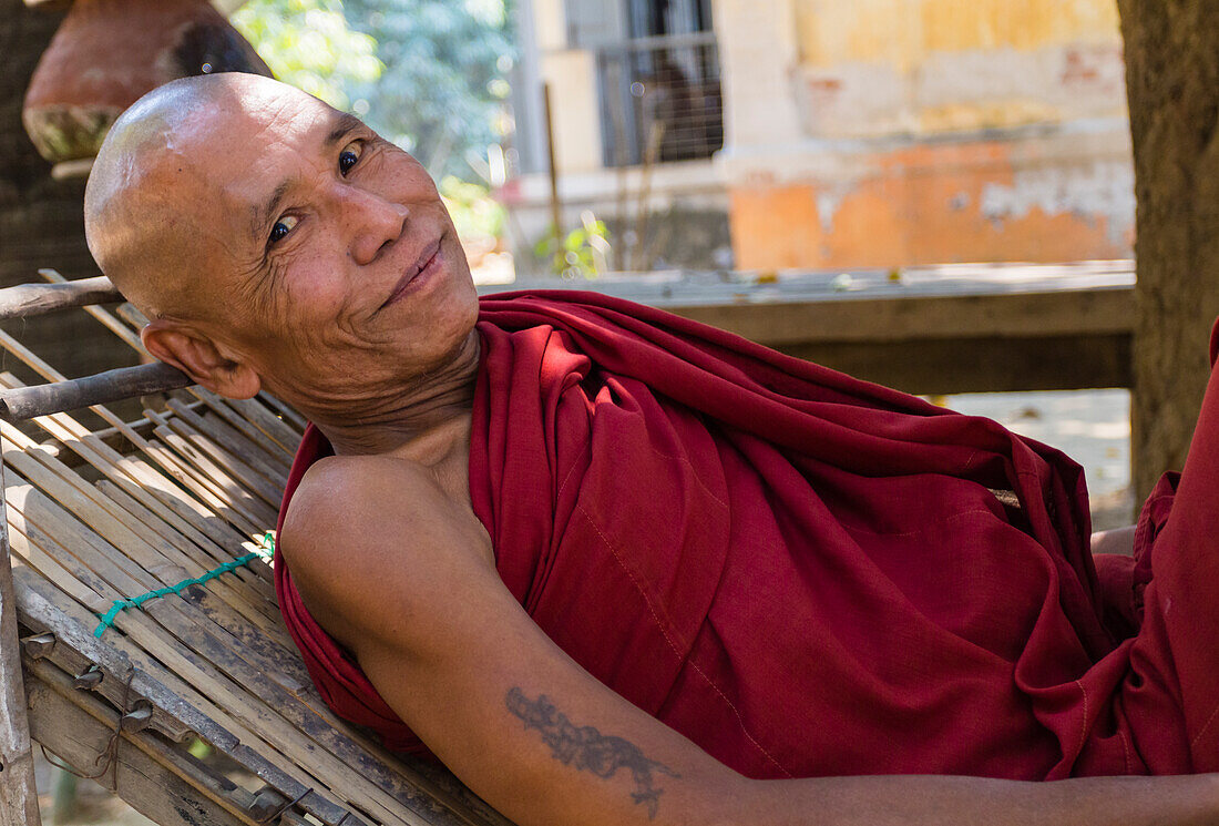 Älterer Mönch auf einem Liegestuhl vor dem Shwenandaw-Tempel, Mandalay, Myanmar (Birma), Asien