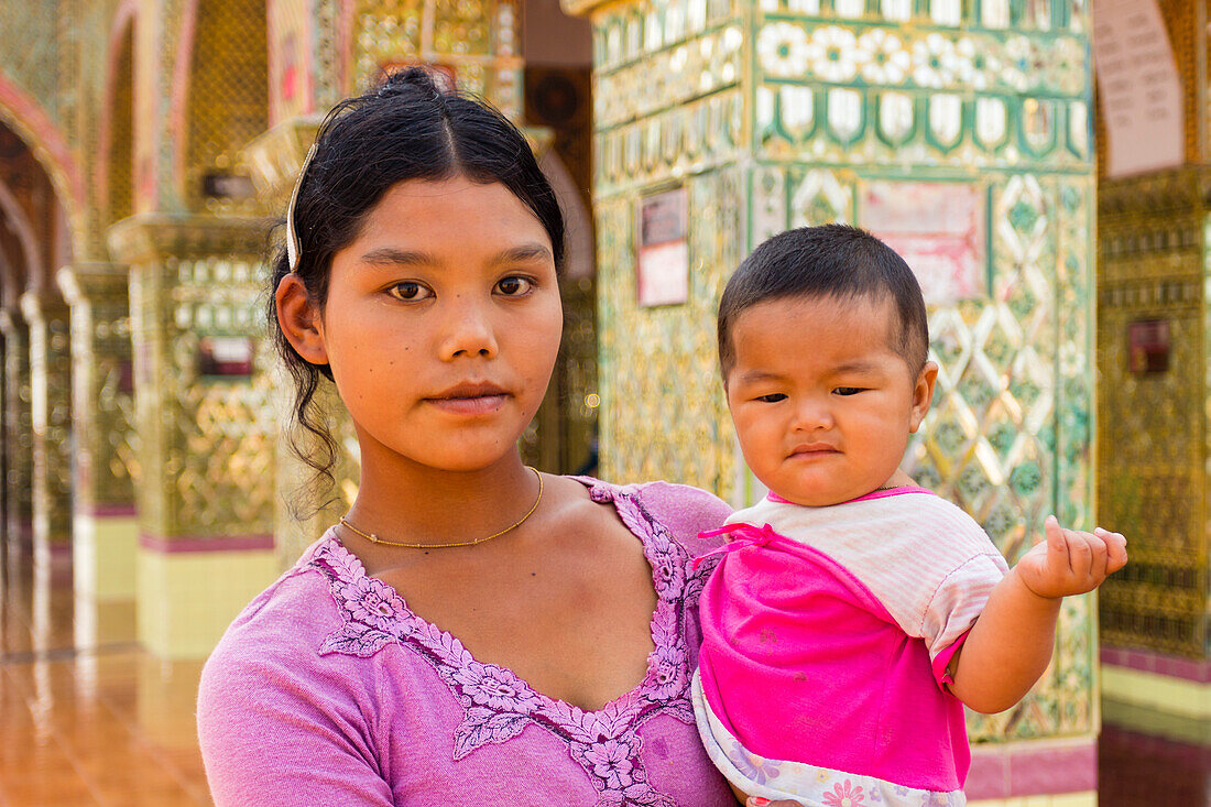 Young Burmese woman holding her small boy and looking at camera, Mandalay Hill, Mandalay, Myanmar (Burma), Asia