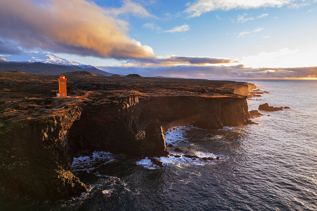 Aerial view of the orange Svortuloft lighthouse on top of the basalt cliffs at sunset, Snaefellsbaer, Snaefellsjokull National Park, Snaefellsens peninsula, Vesturland, West Iceland, Iceland, Polar Regions