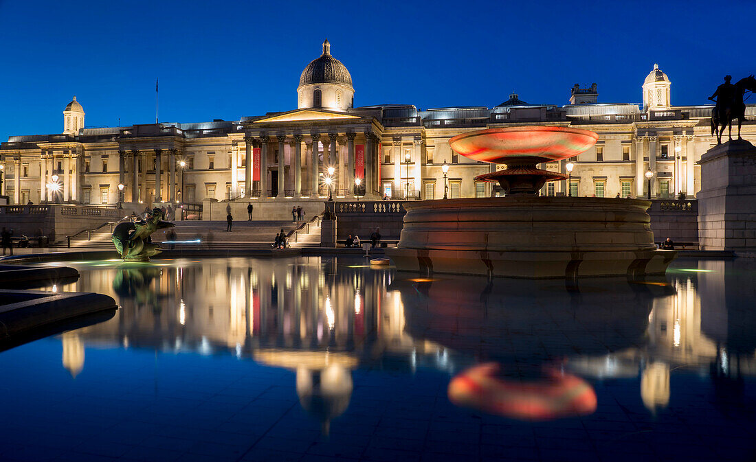 Trafalgar Square und National Gallery in der Abenddämmerung mit Spiegelung im Brunnen, London, England, Vereinigtes Königreich, Europa