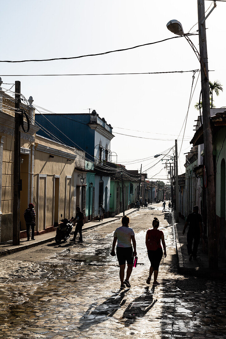 Typische Seitenstraße mit silhouettierten jungen Frauen, die hinuntergehen, Trinidad, Kuba, Westindien, Karibik, Mittelamerika