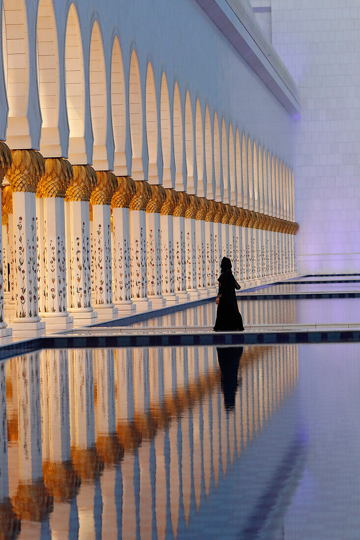 Muslimische Frau in schwarzer Abaya in der Großen Scheich-Zayed-Moschee, die Moschee hat 1096 Säulen an der Außenseite, Abu Dhabi, Vereinigte Arabische Emirate, Naher Osten