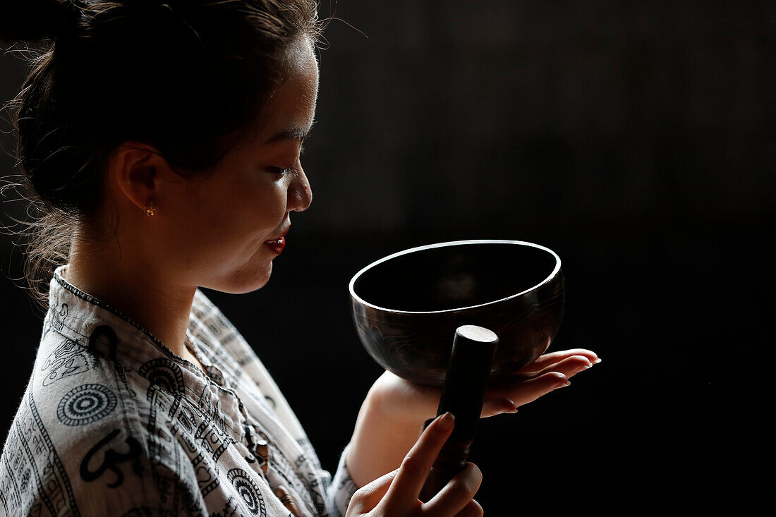 Tibetan bowl, Buddhist woman practising a singing bowl for sound therapy in atmosphere for healing, meditation, yoga and relaxation, Quang Ninh, Vietnam, Indochina, Southeast Asia, Asia