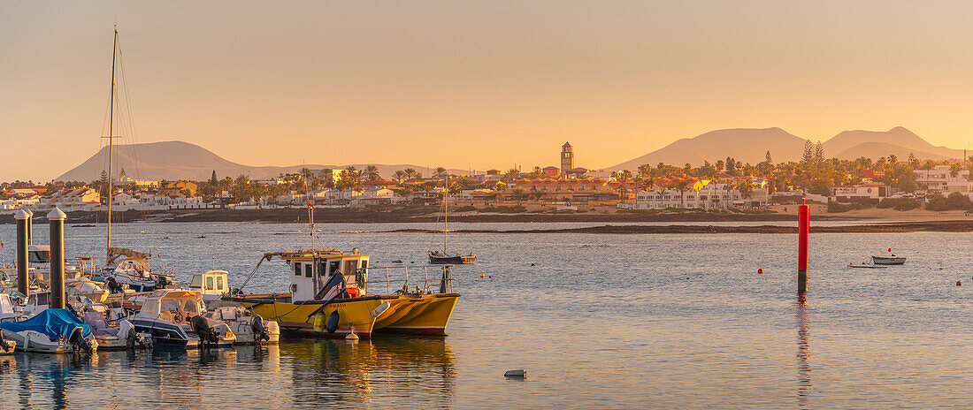 View of harbour boats and Corralejo at sunset, Corralejo, Fuerteventura, Canary Islands, Spain, Atlantic, Europe