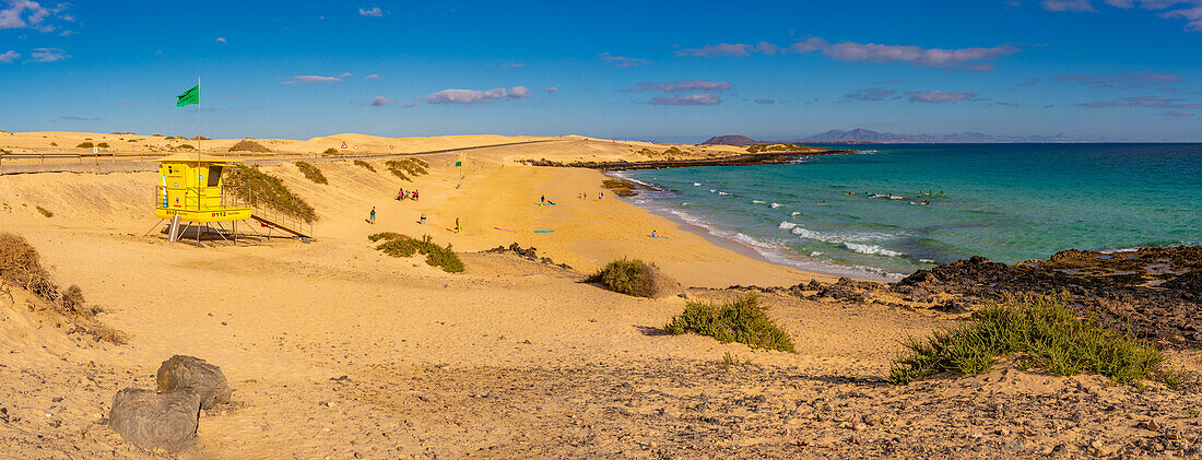 Blick auf Strand, Surfer und den Atlantik an einem sonnigen Tag, Naturpark Corralejo, Fuerteventura, Kanarische Inseln, Spanien, Atlantik, Europa