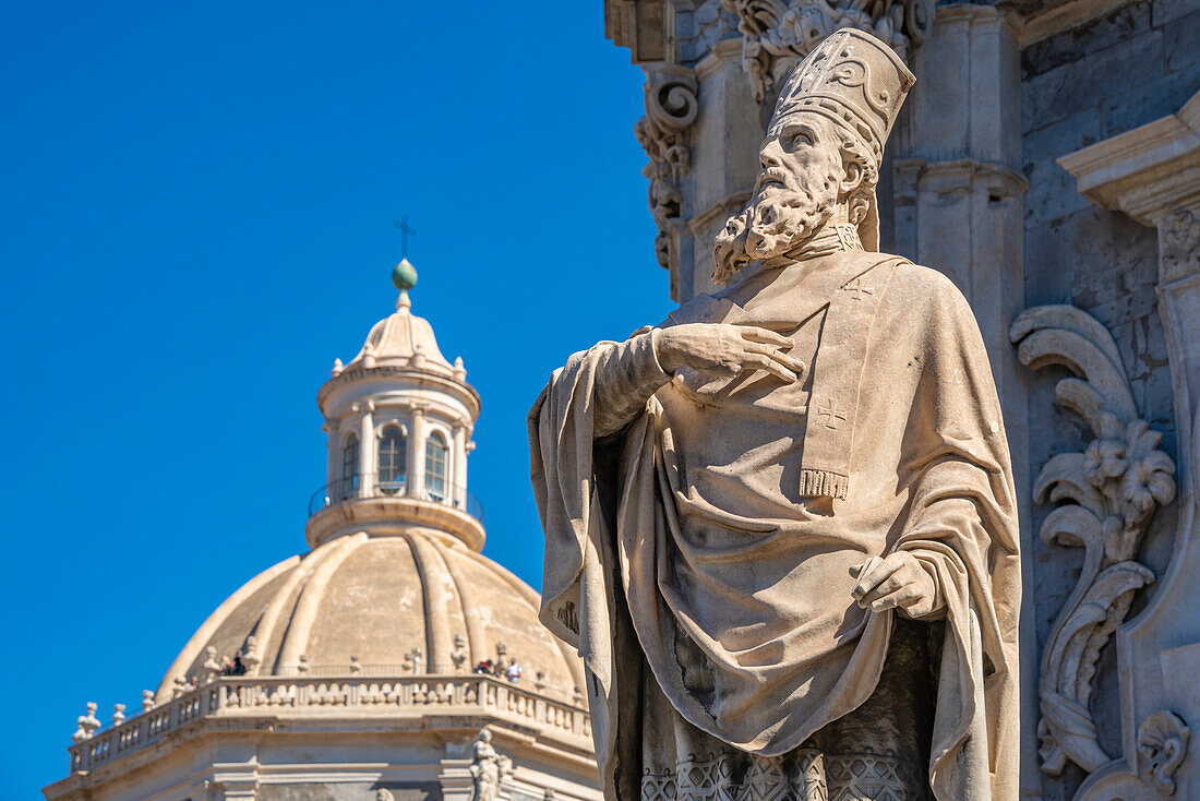 View of statue at the Duomo and Chiesa della Badia di Sant'Agata rotunda from Piazza Duomo, Catania, Sicily, Italy, Mediterranean, Europe