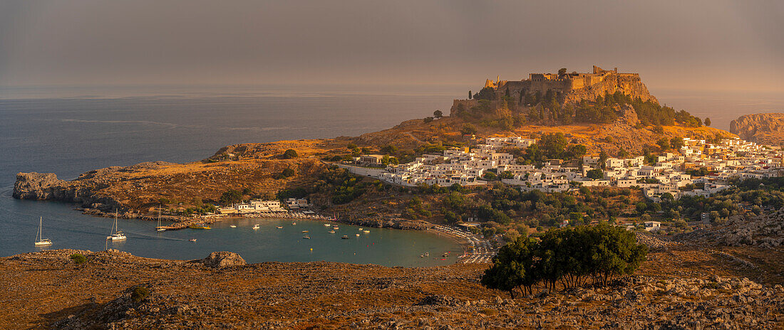 Blick auf Segelboote in der Bucht, Lindos und Lindos Akropolis von erhöhter Position, Lindos, Rhodos, Dodekanes Inselgruppe, Griechische Inseln, Griechenland, Europa