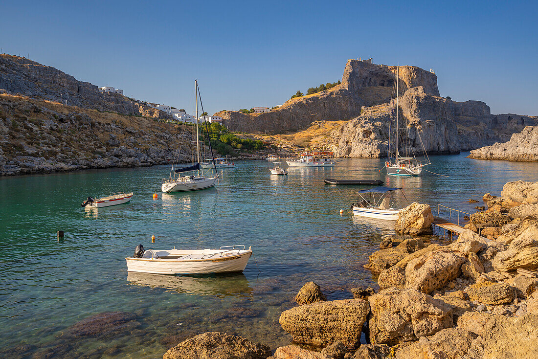 Blick auf Segelboote in der St. Paul's Bay, Lindos und Lindos Akropolis vom Strand aus, Lindos, Rhodos, Dodekanes Inselgruppe, Griechische Inseln, Griechenland, Europa