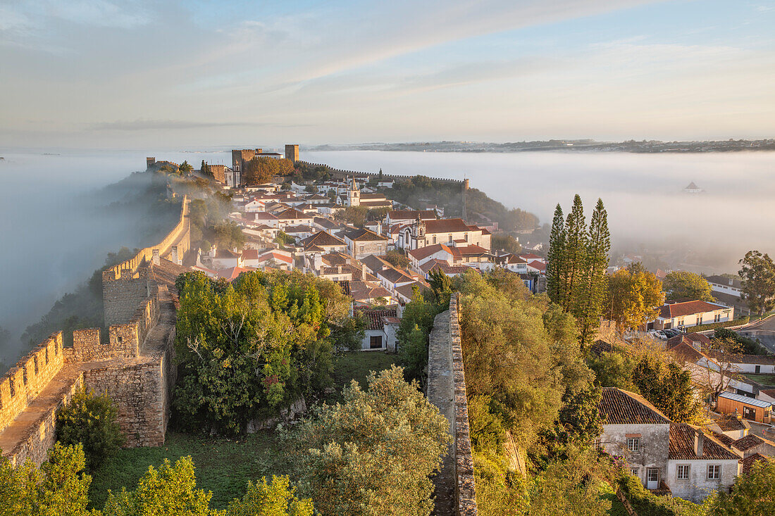 Nebel bei Sonnenaufgang über der Altstadt von Obidos und den Festungsmauern, Obidos, Centro Region, Estremadura, Portugal, Europa
