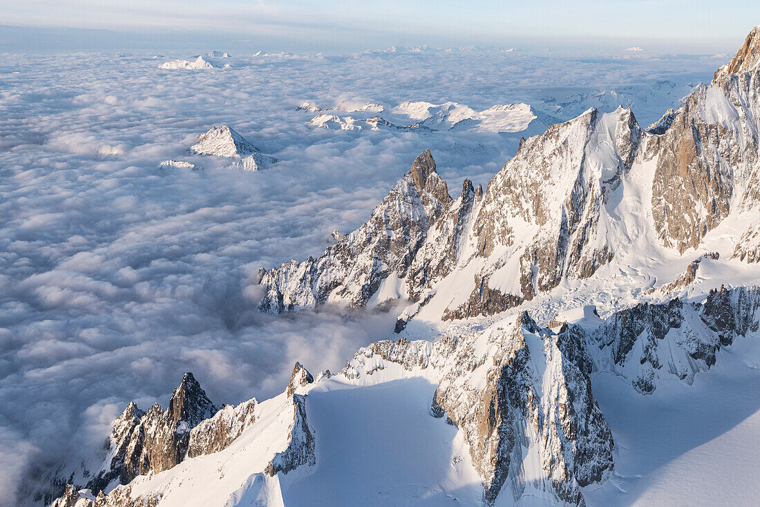 Luftaufnahme des verschneiten Gipfels der Aiguille Noire De Peuterey während des Sonnenaufgangs, Courmayeur, Aostatal, Italien, Europa