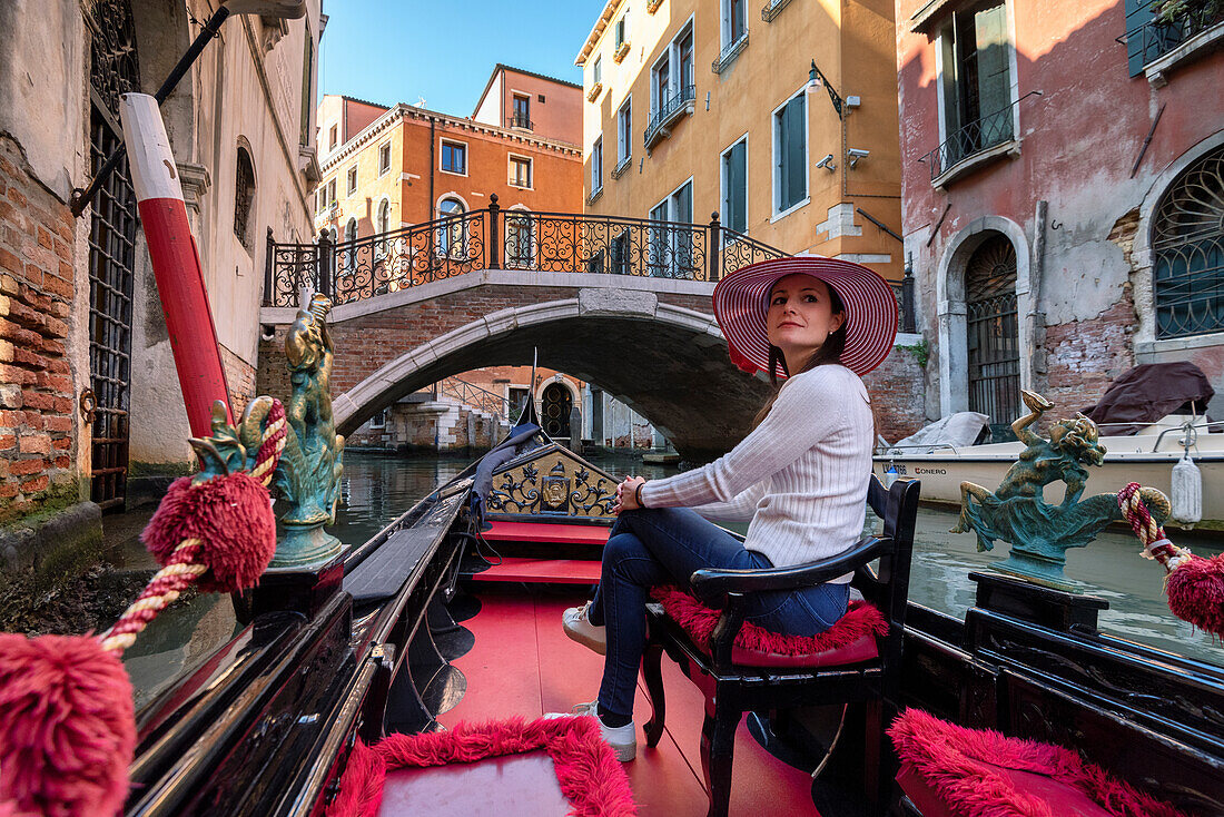 Young girl in a gondola tour in Venice, Veneto, Italy, Europe