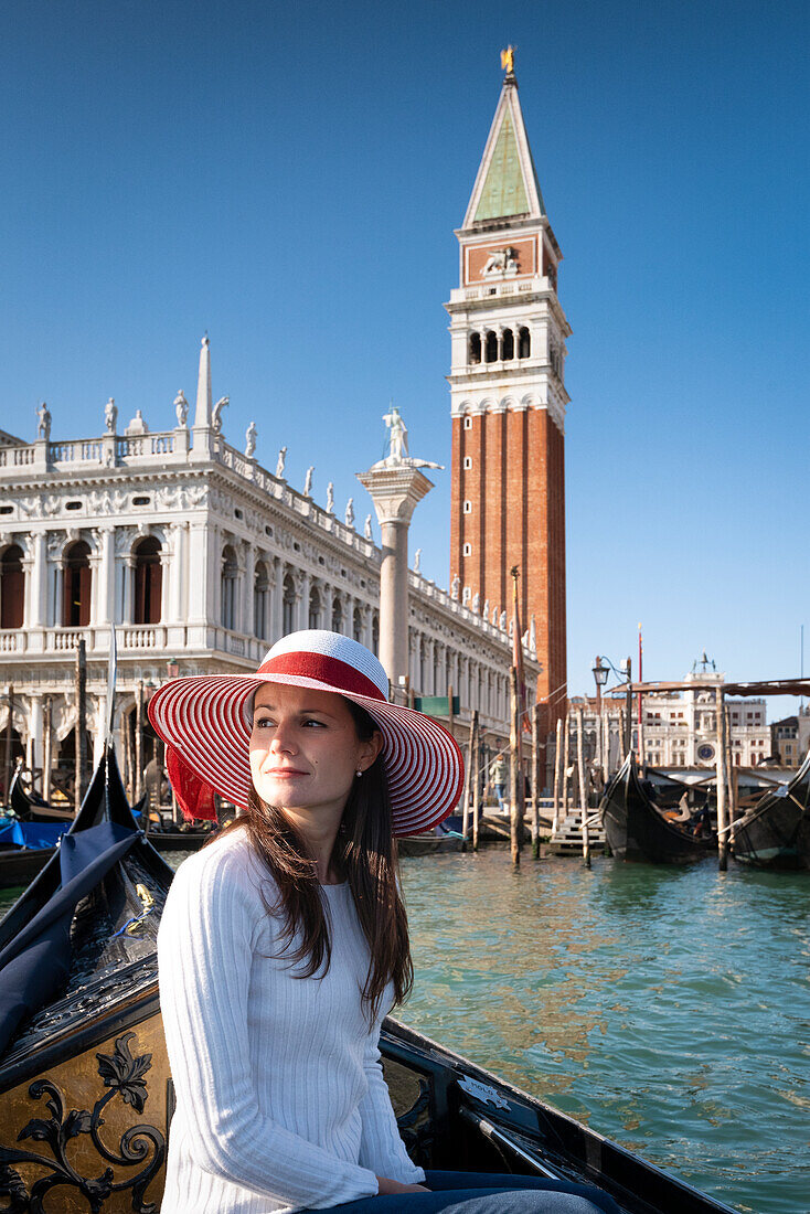Young girl in a gondola tour in front of St Mark square in Venice, Veneto, Italy, Europe