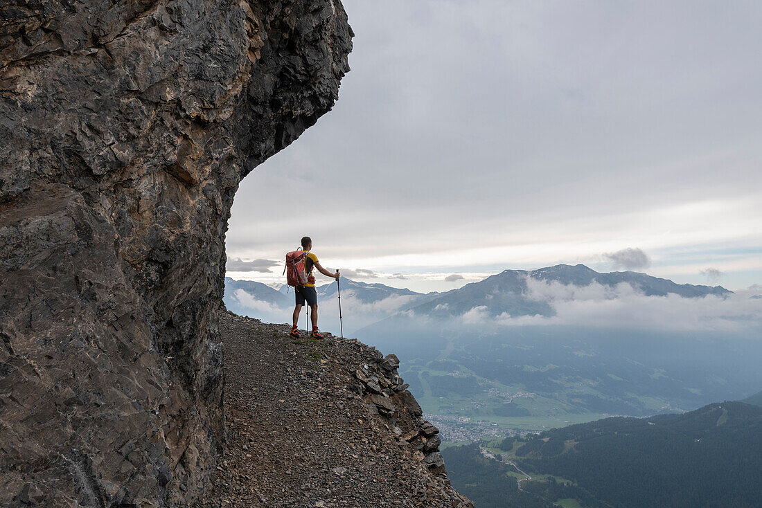 Hiker admires landscape from hold trail of Monte Scale, Valdidentro, Sondrio Province, Valtellina, Lombardy, Italy, Europe