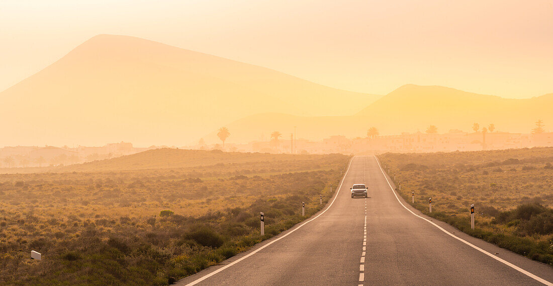 Blick auf Straße und Tinajo im Hintergrund, Tinajo, Lanzarote, Las Palmas, Kanarische Inseln, Spanien, Atlantik, Europa