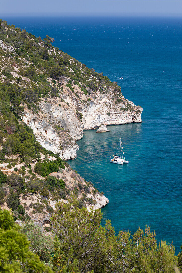 Yacht anchored off coastline near Cala del Pescecane, Gargano peninsula, Foggia Province, Puglia, Italy, Europe