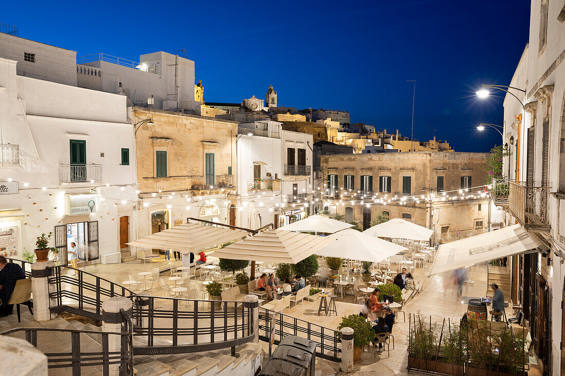 Abends beleuchtete Restaurants auf der Piazza della Liberta, Ostuni, Provinz Brindisi, Apulien, Italien, Europa