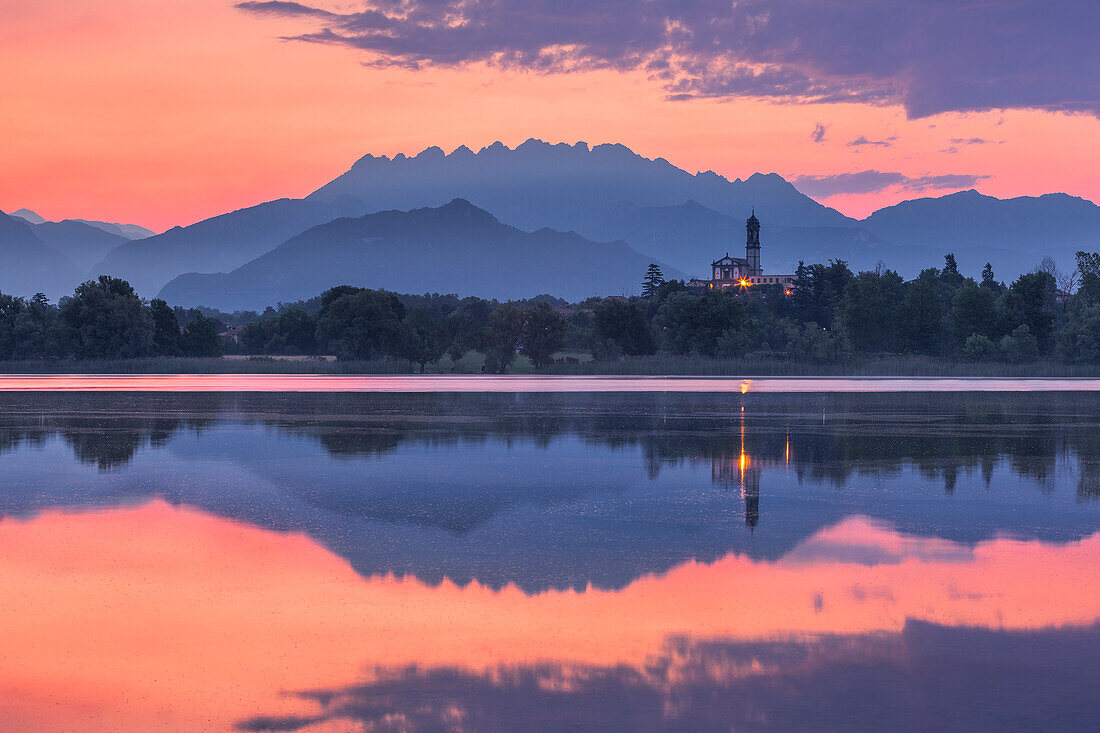 Sonnenaufgang auf dem Berg Resegone und Barro, der sich im See von Pusiano spiegelt, Kirche von Garbagnate Rota, Provinz Lecco, Lombardei, Italien, Europa