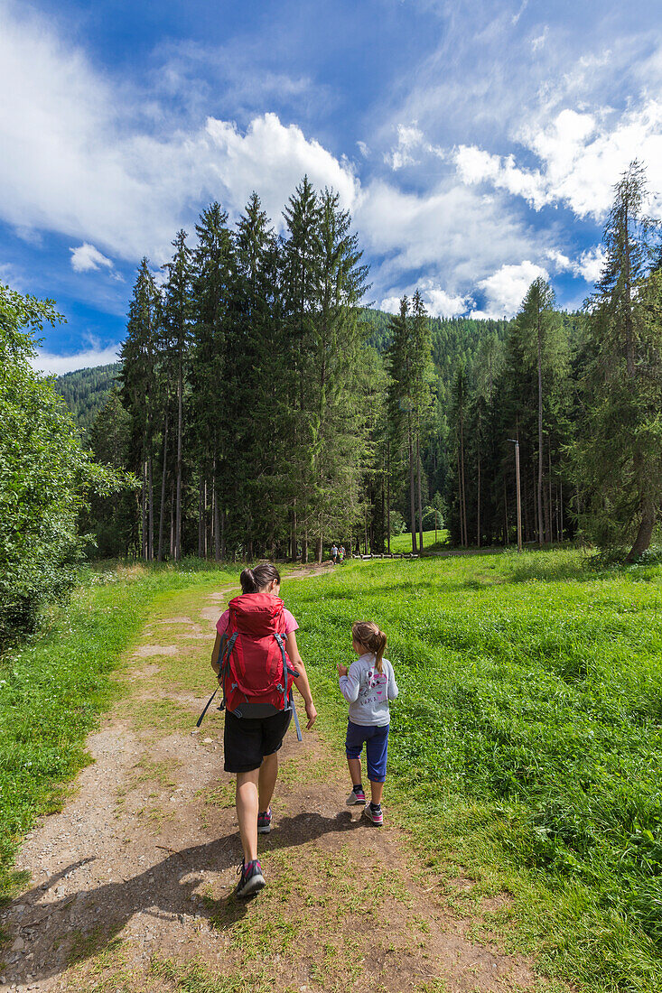 Mom and daughter walk on the path to reach Bagni di Rabbi, Rabbi valley (val di Rabbi), Trento province, Trentino-Alto Adige, Italy, Europe (MR)