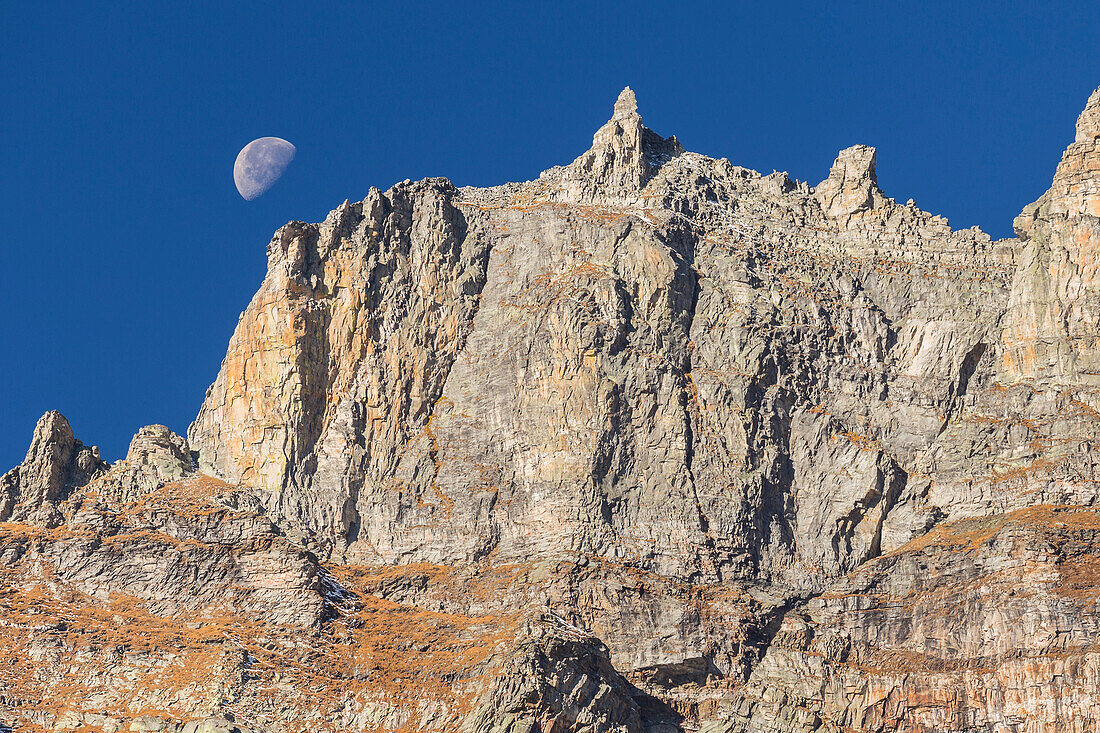 Sunset of the moon behind mountains of Alpe Devero, Nero lake (lago Nero), Baceno, Alpe Veglia and Alpe Devero natural park, province of Verbano-Cusio-Ossola, Piedmont, italy, Europe