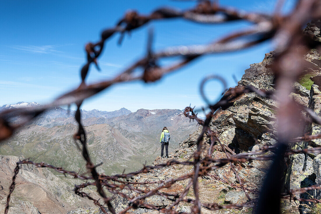 Mädchen wurde von Überresten des Ersten Weltkriegs im Gavia-Tal, Valtellina, Provinz Sondrio, Lombardei, Italien, Europa eingerahmt