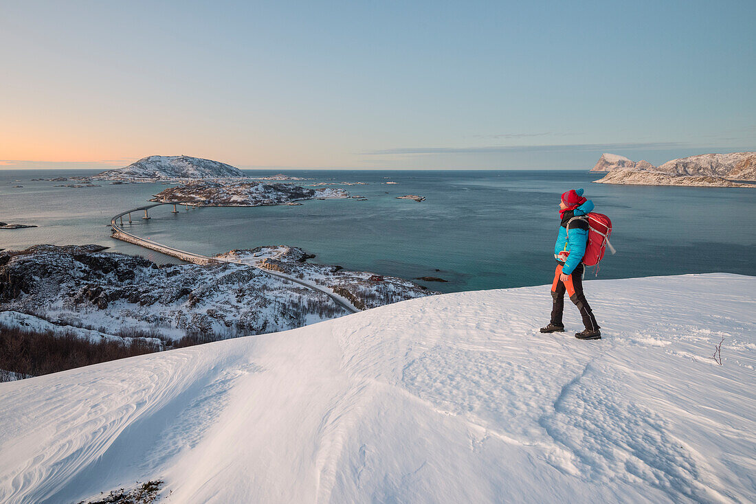 Mann schaut auf die Brücke und das Meer, Insel Sommaroy, Provinz Troms, Norwegen, Europa