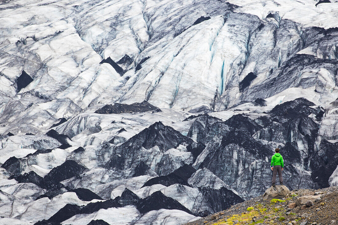 ein Junge bewundert den Sólheimajökull-Gletscher an einem Sommertag, Sudurland, Island, Europa
