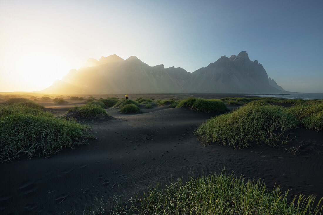 eine Person bewundert den Berg Vestrahorn während eines Sonnenuntergangs, Stokksnes, Hofn, Ostisland, Island, Europa.