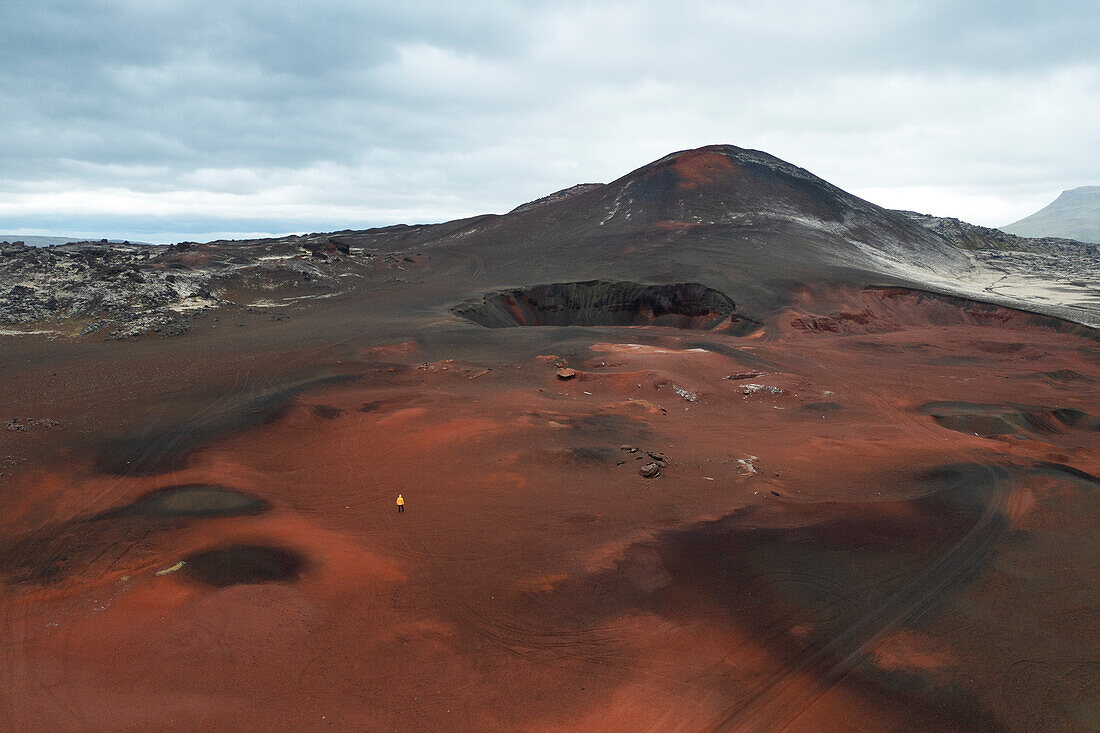 eine Person genießt die Landschaft in der Nähe eines isländischen Vulkangebietes, Vesturland, Island, Europa