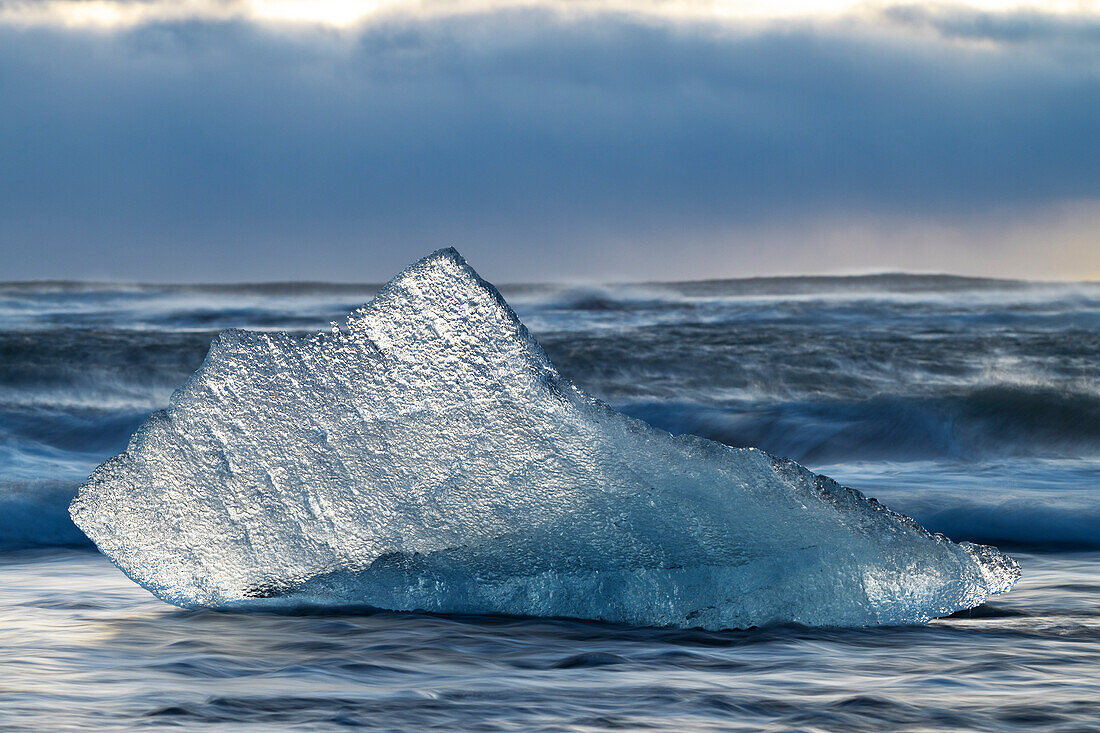 ein Eisblock am Diamond Beach während eines Sonnenuntergangs im Winter, Jokusarlon Gletscherlagune, Austurland, Island, Europa