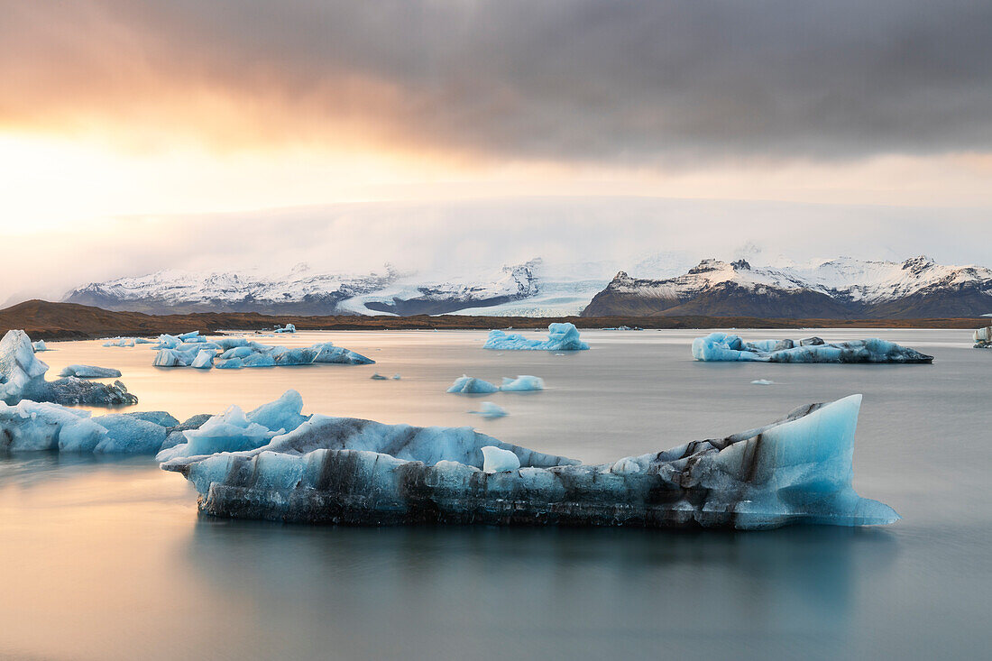 ein kleiner Eisberg in der Jokusarlon Gletscherlagune, während eines warmen Wintersonnenuntergangs, Austurland, Island, Europa