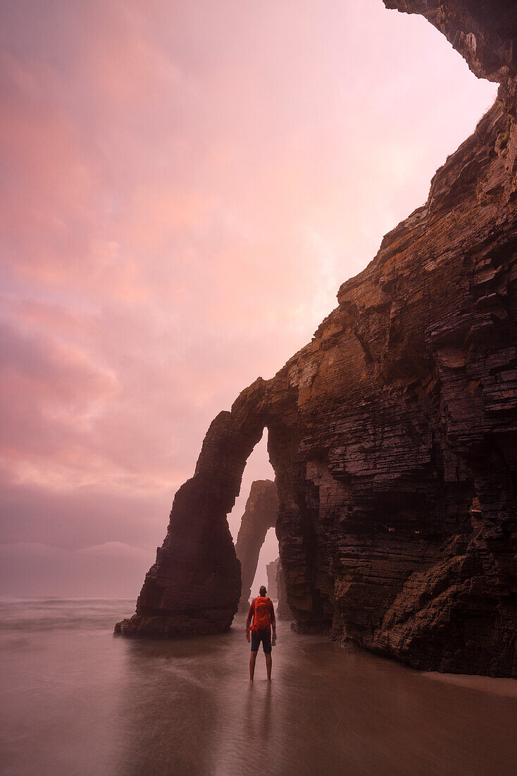 one tourist enjoy the sunset during a low tide at Praia de As Catedrais, Galixia, Spain, Europe