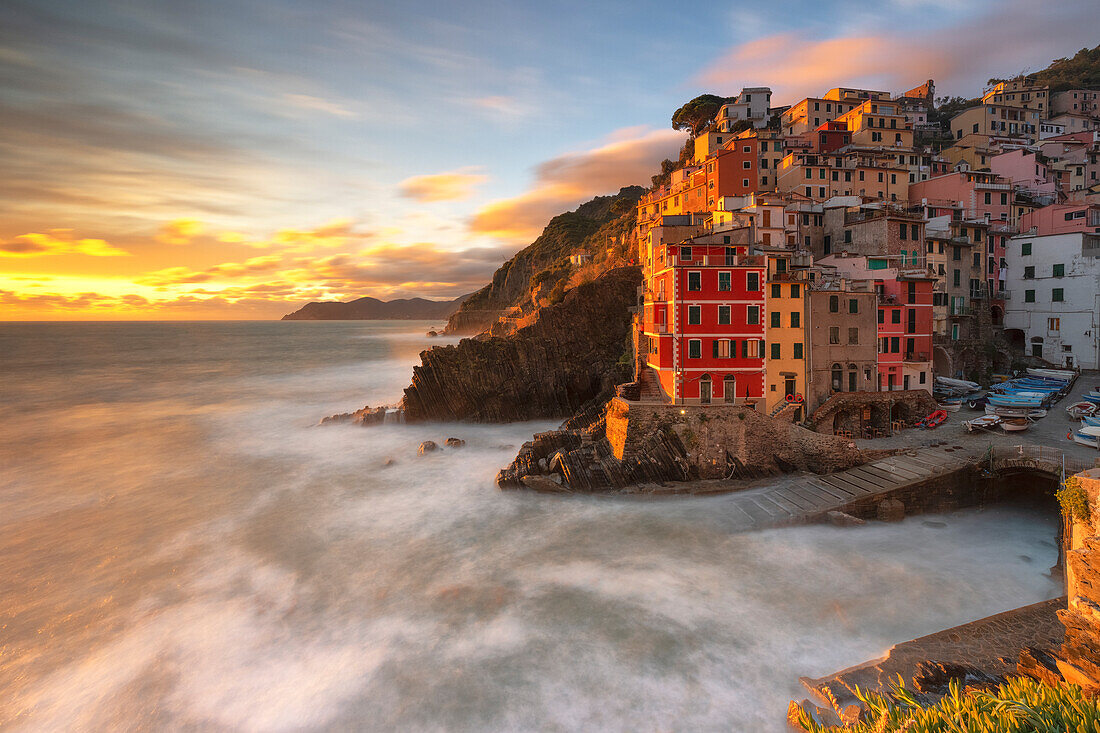 a long exposure to capture the sunset from the riomaggiore harbor surrounded by a warm light, National Park of Cinque Terre, municipality of Riomaggiore, UNESCO WORLD HERITAGE SITE, La Spezia province, Liguria district, Italy, Europe