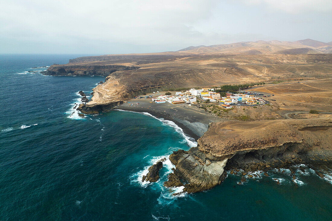 Luftaufnahme einer Drohne von einem kleinen Fischerdorf namens Puerto de la Pena, während eines Sommertages, Fuerteventura, Kanarische Insel, Spanien, Europa