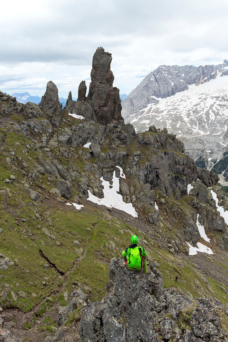 A hiker rests along the Via Ferrata delle Trincee, Padon Group, Dolomites, Fassa Valley, Trento Province, Trentino-Alto Adige, Italy.
