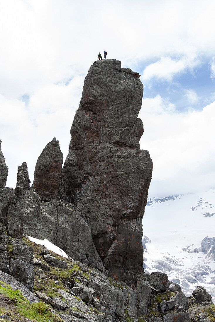 Zwei Bergsteiger auf dem Gipfel des Einsiedlerturms (Torrione dell'Eremita) entlang des Klettersteigs Via Ferrata delle Trincee, Padon-Gruppe, Dolomiten, Fassa-Tal, Provinz Trient, Trentino-Südtirol, Italien.