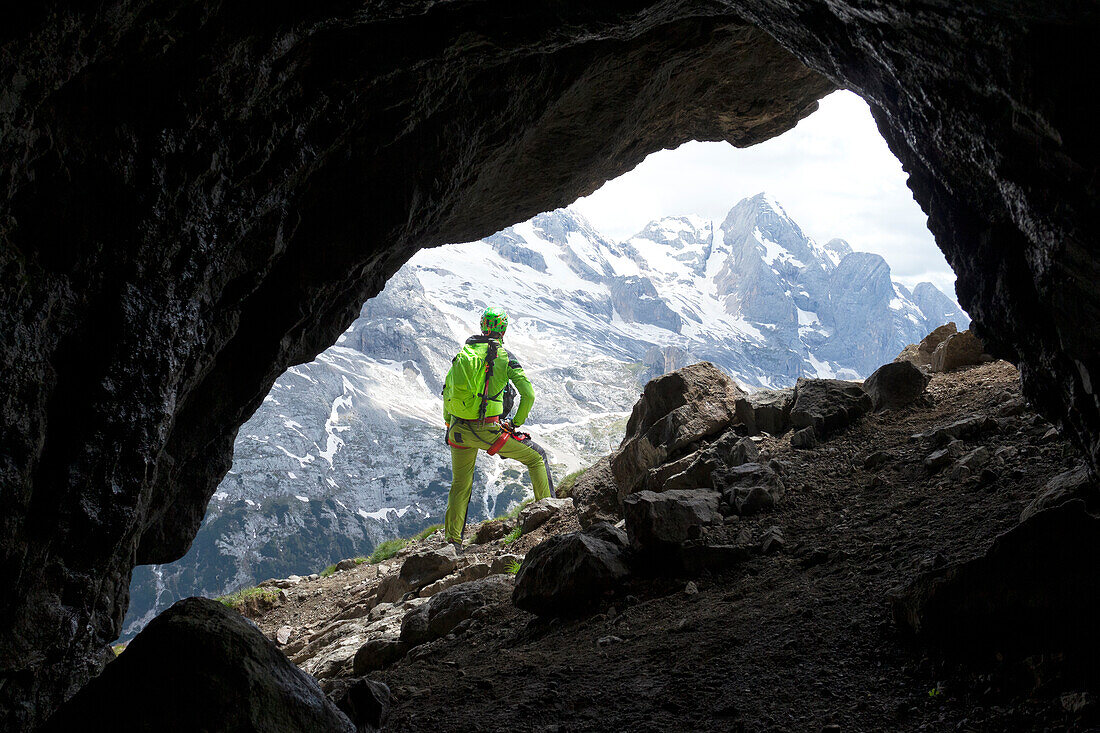A hiker admires Gran Vernel at the exit of a war gallery along the Via Ferrata delle Trincee, Padon Group, Dolomites, Fassa Valley, Trento Province, Trentino-Alto Adige, Italy.