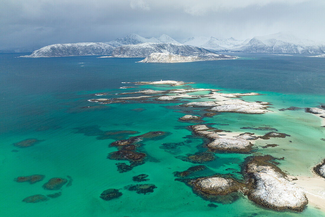 Luftaufnahme einer Drohne von den Schären nahe der Insel Sommaroy an einem bewölkten Wintertag, Provinz Troms, Nordnorwegen, Europa